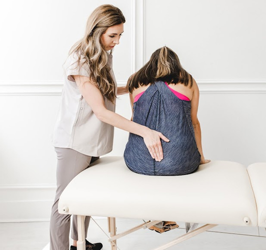 Dr Nikki Berner treating patient on bed that is experiencing lower back pain